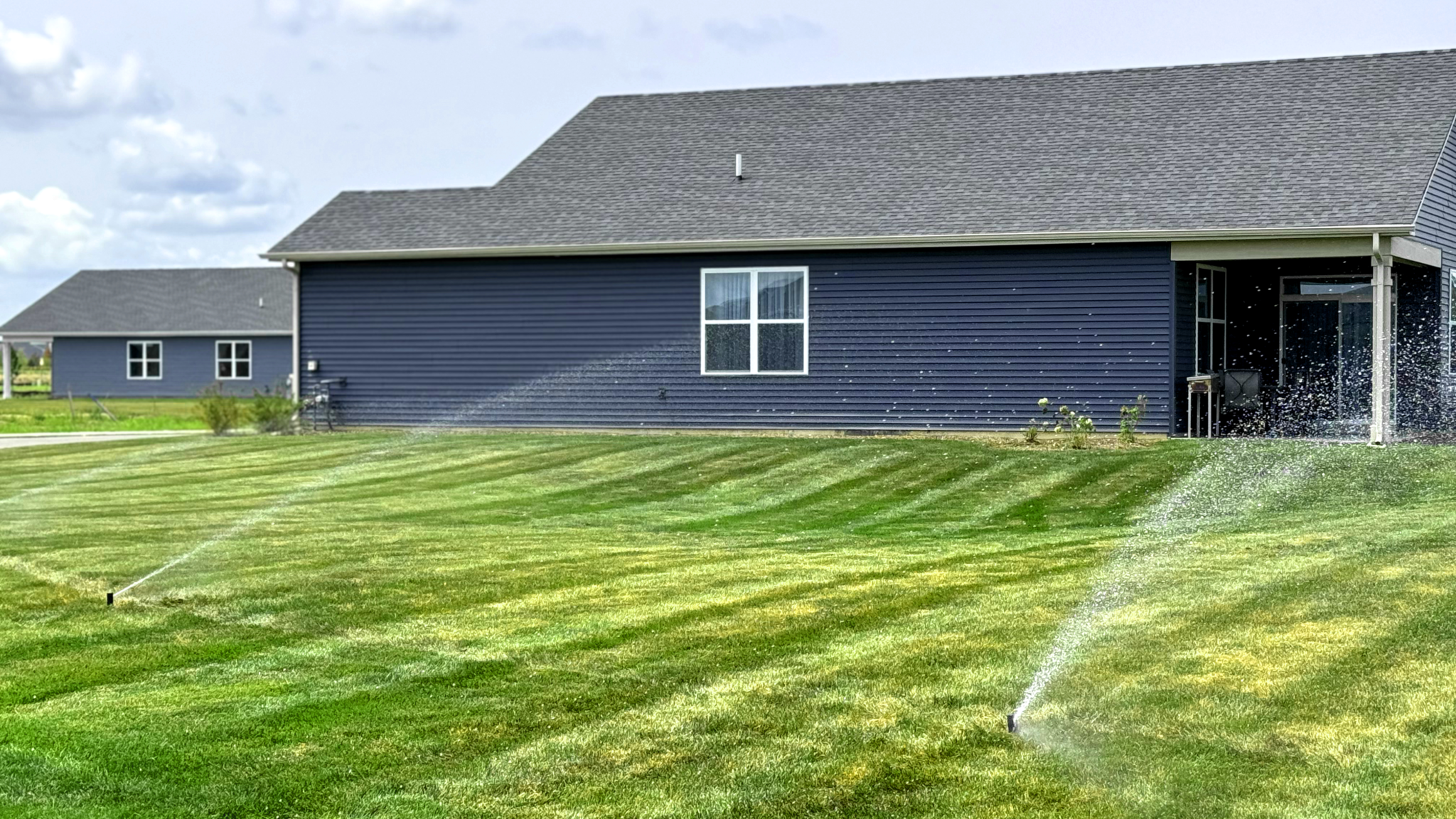Sprinkler watering a healthy lawn